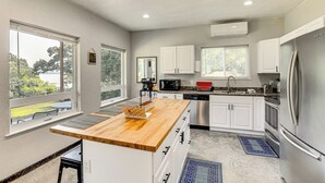 A modern kitchen with white cabinets, stainless steel appliances, and a wooden countertop. - Frankston Vacation Rental: Walk to Lake Palestine! (Frankston)