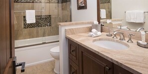 A modern bathroom with a large sink, vanity, and a bathtub.