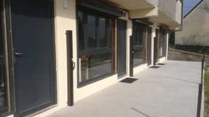 A building with large windows and a concrete exterior. - Location de Courte Durée Studio Meublé (Le Trait)
