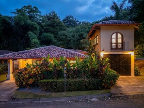 A two-story house with a tiled roof and a gated entrance.