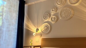 Ett hotellrum med en snyggt bäddad säng, en sänggavel i trä och dekorativa väggpaneler.