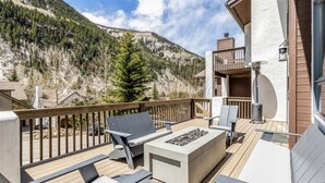A deck with outdoor seating, a fire pit, and a mountain view. - 4 Bedroom Luxury Home in East Vail (Vail)