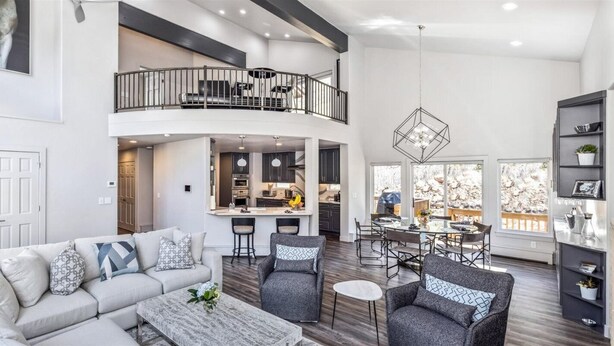 A spacious living area with a high ceiling, a balcony, a kitchen, and a dining area. - 4 Bedroom Luxury Home in East Vail (Vail)