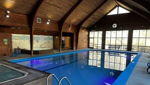 An indoor swimming pool with wooden beams, a hot tub, and a sauna area. - The Dogwood condo is located in the heart of Sapphire Valley with WiFi, AC  (Sapphire)
