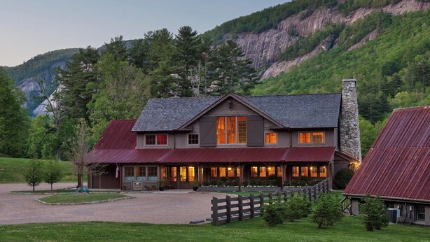 A two-story building with a stone chimney, a red metal roof, and a well-maintained lawn in front. - The Dogwood condo is located in the heart of Sapphire Valley with WiFi, AC  (Sapphire)