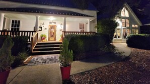 A two-story house with a porch, a front door, and a staircase leading to the entrance. - The Dogwood condo is located in the heart of Sapphire Valley with WiFi, AC  (Sapphire)