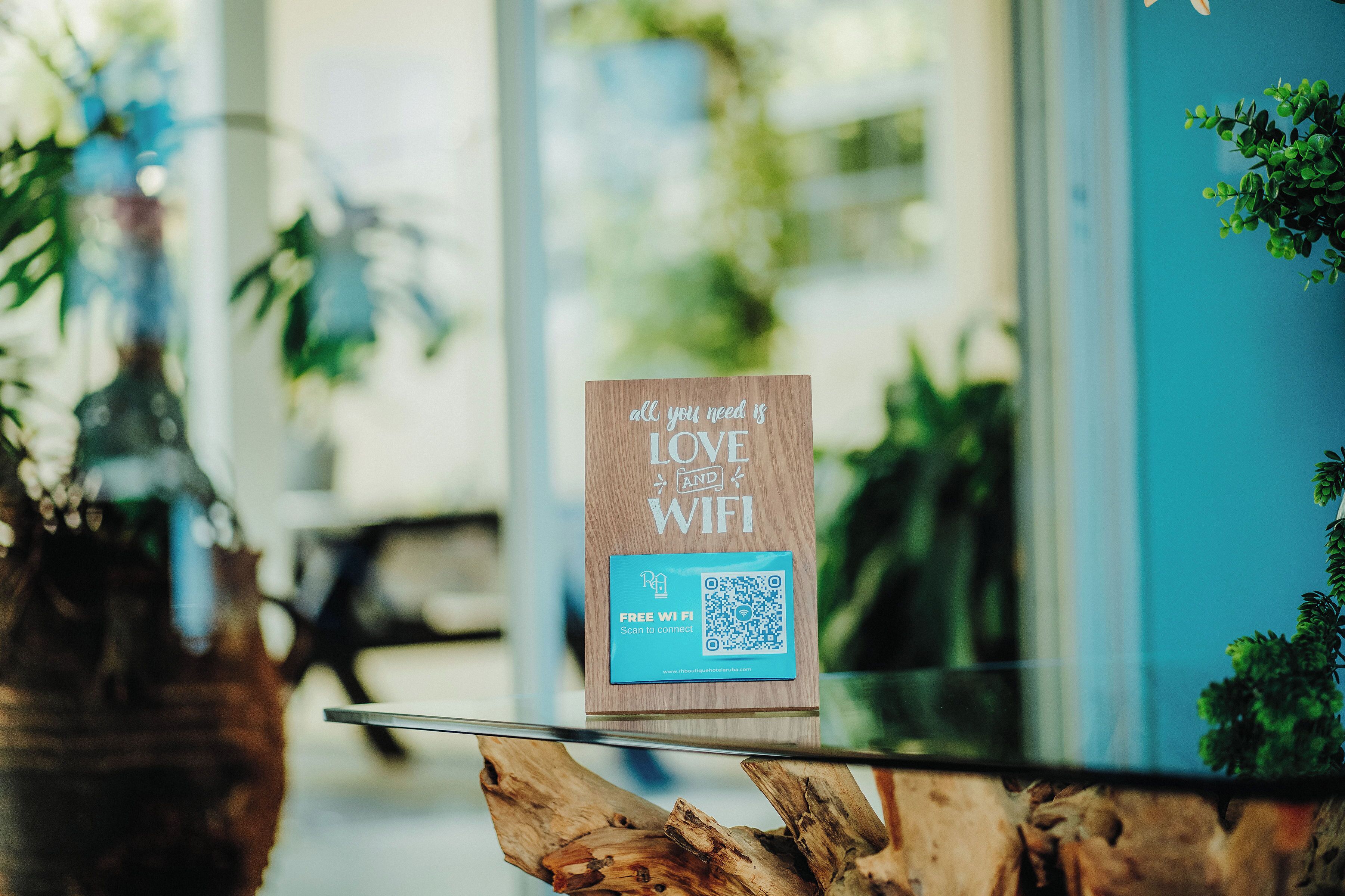 A wooden sign with a QR code on a glass table.