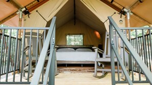 Een tent met een bed, een raam en een deur.