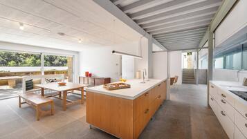 A modern kitchen with a large island, wooden cabinets, and a view of the outdoors.