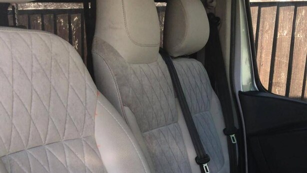 The interior of a vehicle with quilted beige seats and a black door handle. - Do not Book Unavailable (Rhyl)