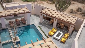 A pool area with wooden loungers, a small pool, and a pergola structure. - Quick walk to Cerritos Beach, private Hot tub, pool, gym, ocean & mountain VIEWS (Los Cerritos)
