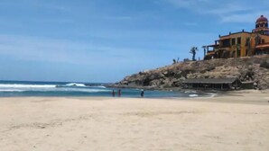 A beach with a building on a rocky outcrop. - Quick walk to Cerritos Beach, private Hot tub, pool, gym, ocean & mountain VIEWS (Los Cerritos)