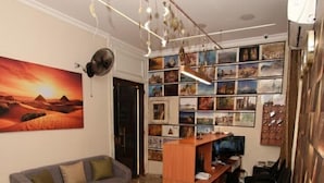 Ein Wohnzimmer mit einer Couch, einem Holztisch, einem Fernseher und einer Wand mit gerahmten Bildern.