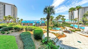 A resort with multiple swimming pools, palm trees, and a well-maintained garden area. - Edgewater Tower 1-105 (Panama City Beach)