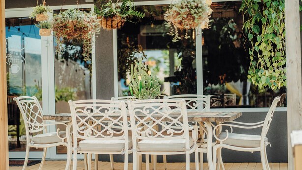 A table with white chairs and hanging plants. - Comfortable and beautiful Suite (Oranjestad)
