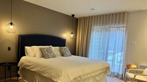 A neatly arranged bedroom with a large bed, two bedside lamps, a bedside table, and a chair. - Modern 3-en-suite Bedroom Townhouse with 1 Sofa Bed and Terrace Mont-Tremblant (Mont-Tremblant)