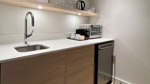A modern kitchen with a built-in dishwasher, a stainless steel sink, and a toaster on the countertop. - Modern 3-en-suite Bedroom Townhouse with 1 Sofa Bed and Terrace Mont-Tremblant (Mont-Tremblant)