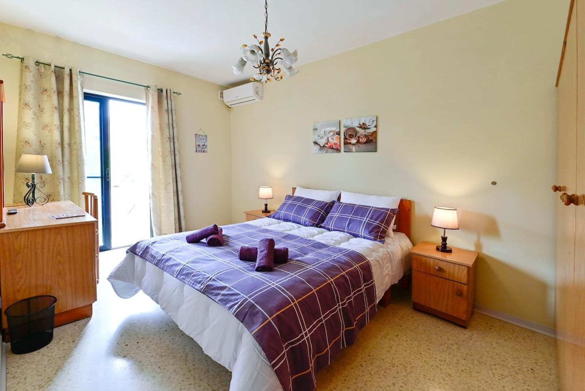 A bedroom with a bed, two bedside tables, a desk, and a chair.