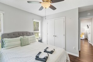 A bedroom with a bed, a ceiling fan, a wardrobe, and a nightstand. - Modern Private Ranch•Very Fast WiFi•Vast Fenced Yard+Big Deck+Fire Pit! (Mint Hill)