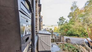 A mailbox with the number 70, a wooden shed, and a garden area with plants and a fence. - Ideal for a Longer Stay or Contractor, Sleeps 1-4 (Cleckheaton)