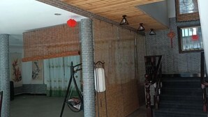 Una habitación con pared de ladrillo, techo de madera y una escalera.
