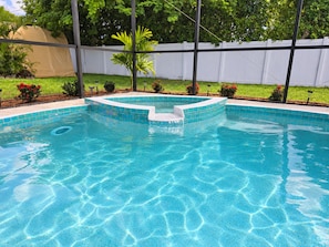 A swimming pool with a tiled edge and a small waterfall feature.