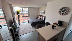 A modern bedroom with a bed, a desk, and a large window. - Elegante Apartamento cerca del Tesoro y Provenza by Hoost 2408 (Medellín)