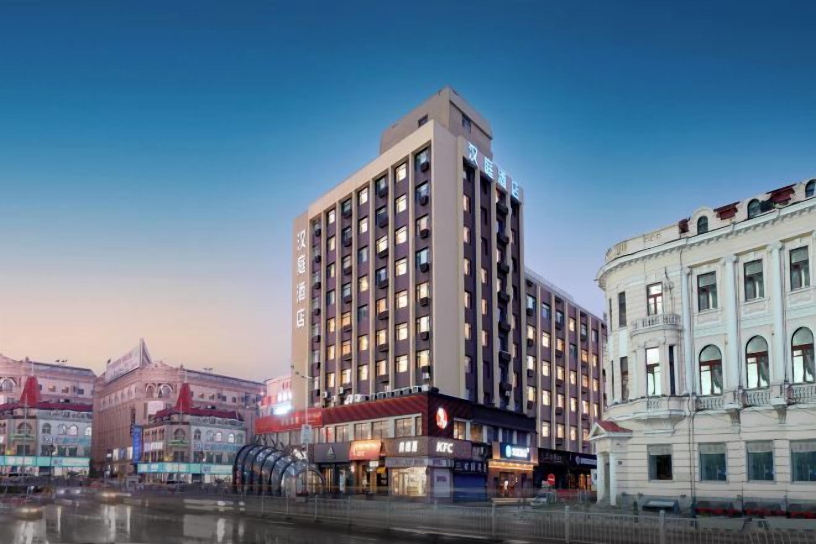 A multi-story hotel with a modern facade, large windows, and a prominent signage.