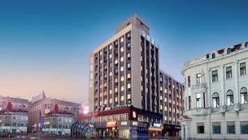Un hotel de varios pisos con fachada moderna, ventanas grandes y señalización destacada.