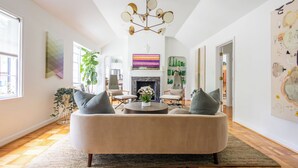 Una sala de estar moderna con un sofá color beige, dos sillones, una mesa de centro redonda y una chimenea.