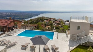 Ein Pool auf dem Dach mit Blick auf einen See und umliegende Gebäude.