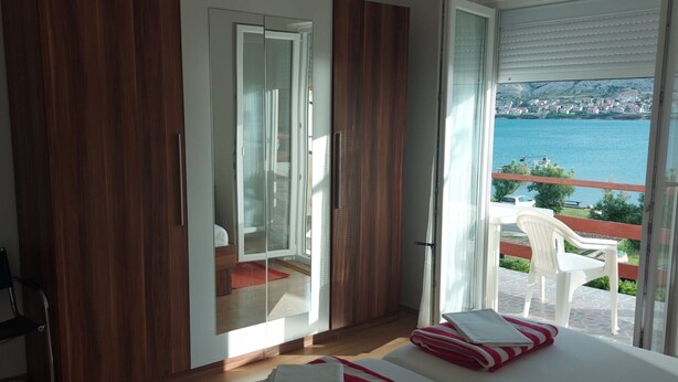 Un dormitorio con un ventanal que ofrece vistas al mar y al paisaje urbano.