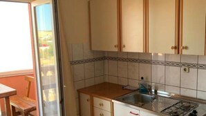 Una cucina con mobili in legno, un fornello a gas e un lavello.