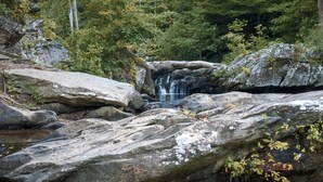 A natural landscape with a waterfall, large rocks, and surrounding greenery. - Luxury Spacious Glamping, Wooded View, Grill, Pool, Pet Friendly, Swim (Delta)