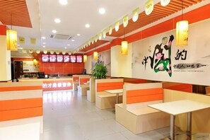 A restaurant with booths and tables, a counter, and a menu display. - Guangzhou Bisheng Hotel (Hengsha Subway Station Branch) (Guangzhou)