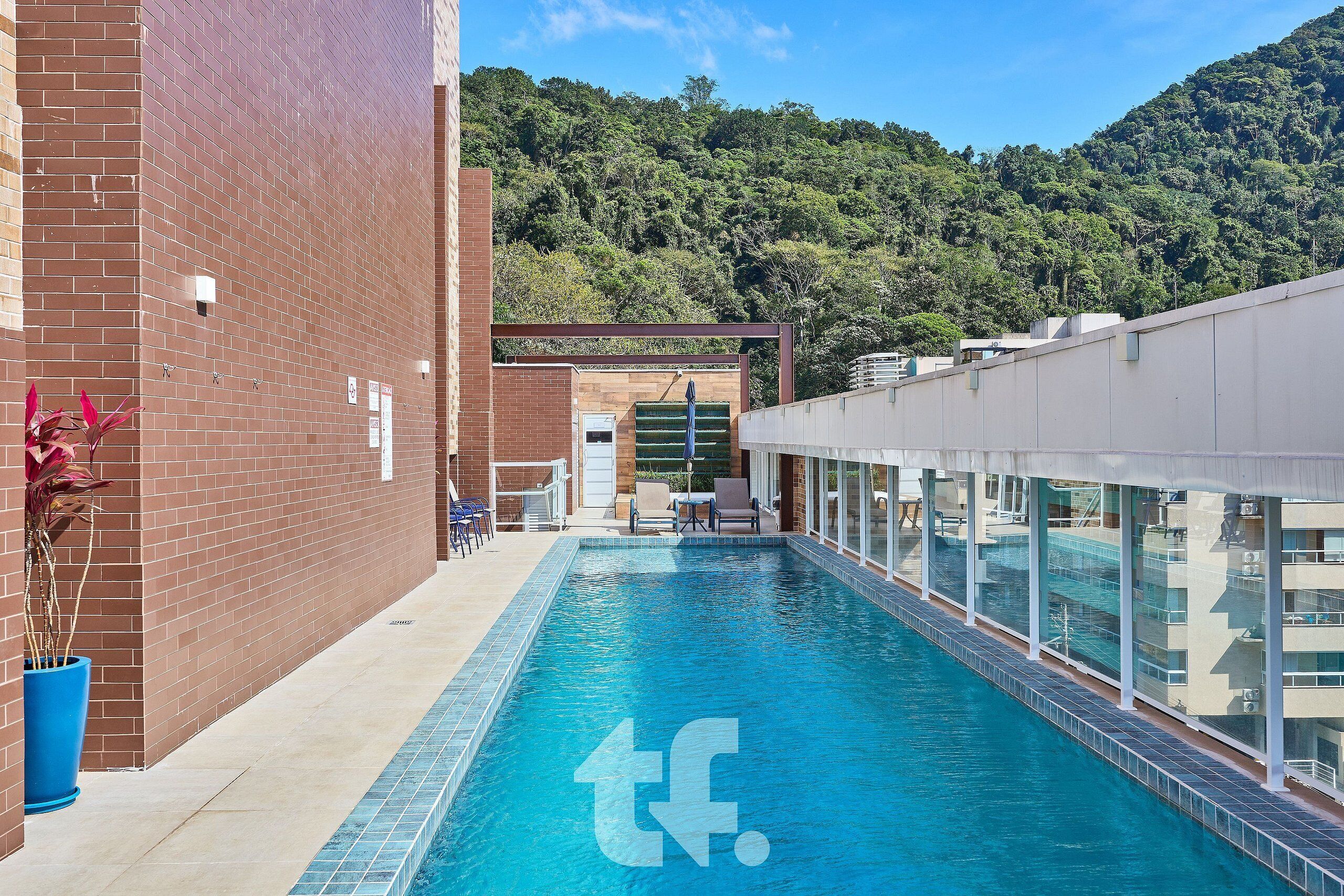 A swimming pool with a view of a forested hillside.