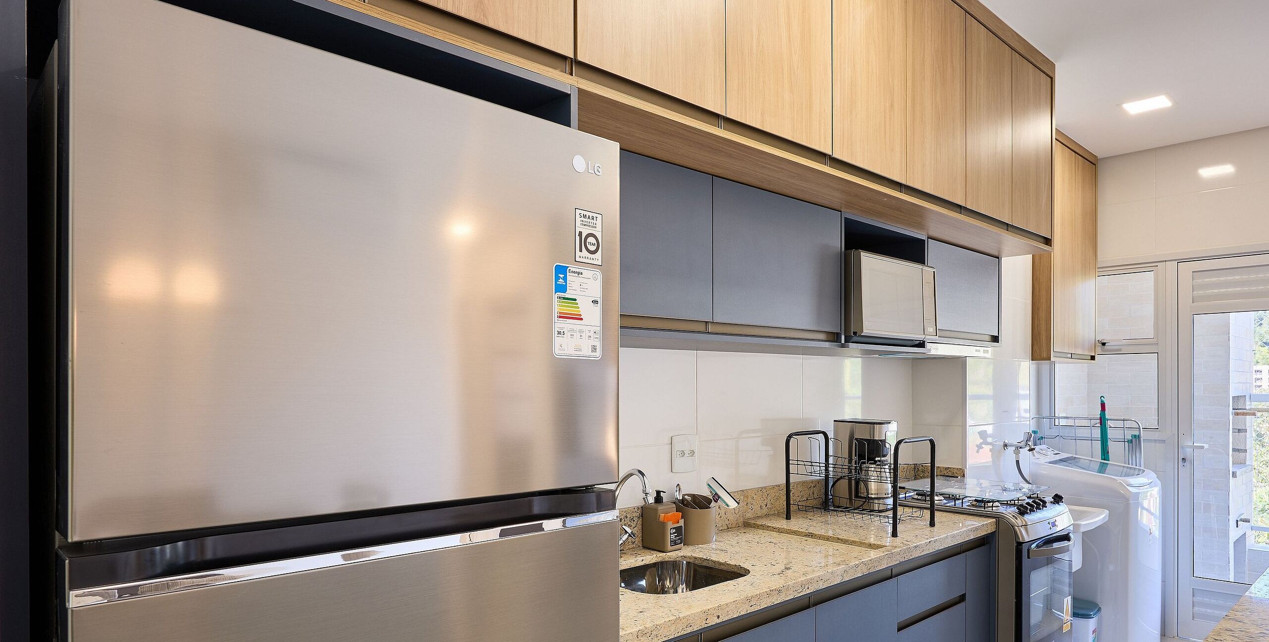 A modern kitchen with stainless steel appliances, wooden cabinets, and a granite countertop.