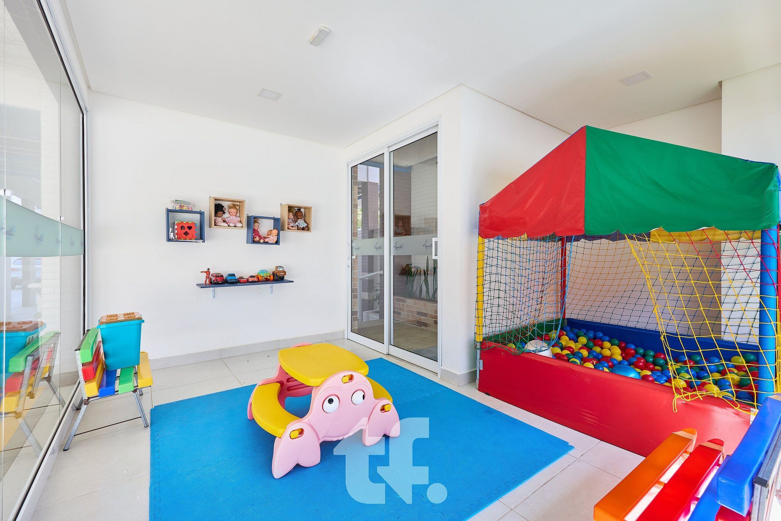A children's play area with a ball pit, a soft play mat, and a climbing structure.