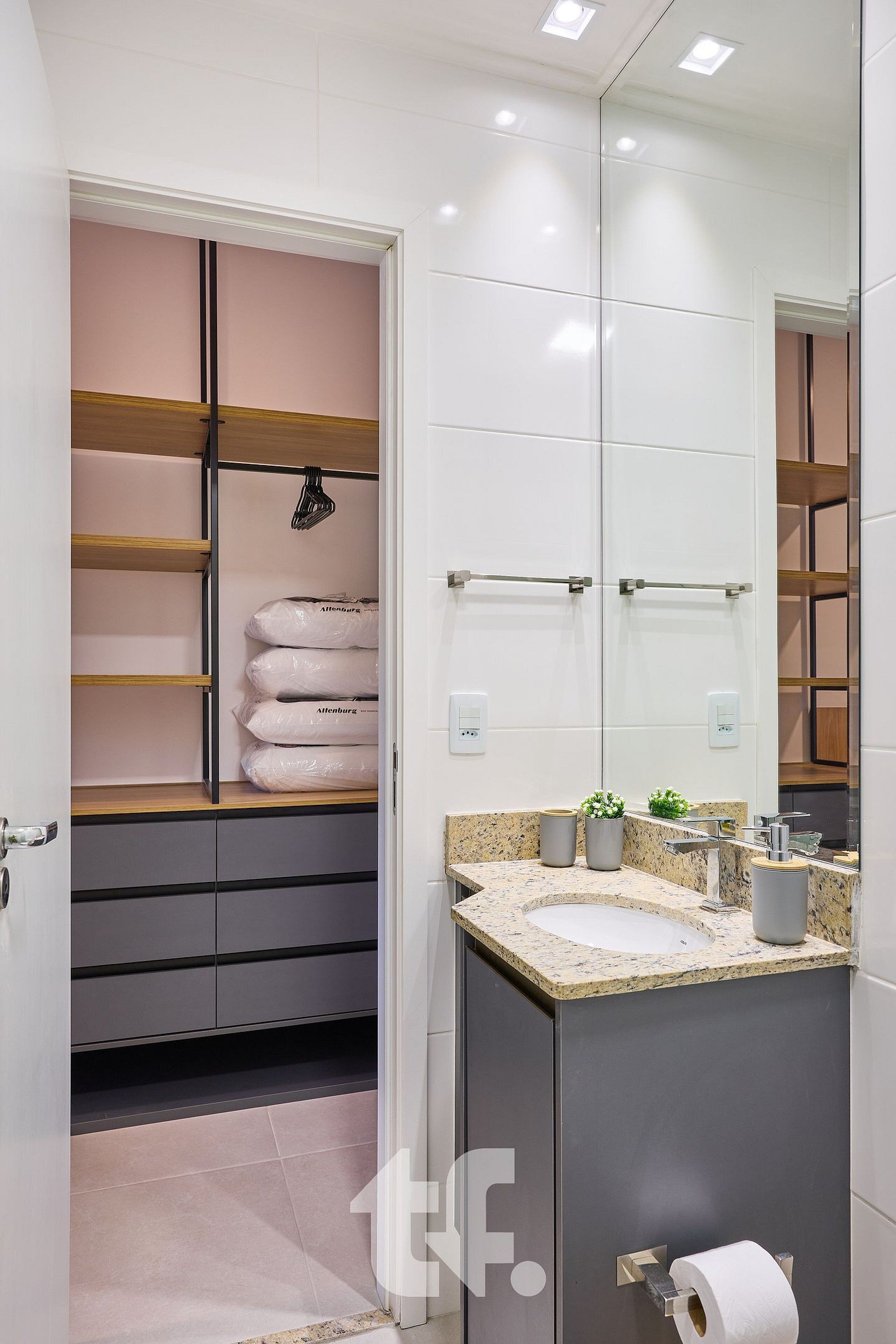 A modern bathroom with a vanity, a large mirror, and a storage unit with shelves.