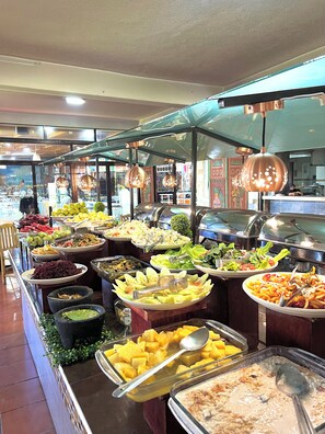 A buffet with various food options, including fruits, salads, and desserts. - Hotel El Jaguar (Teotihuacan)