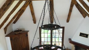 A rustic room with a wooden ceiling, a large wooden wheel chandelier, a fireplace, and a sofa. - New gîte in vimenet (Aveyron) medieval village between aubrac and lévézou  (Vimenet)
