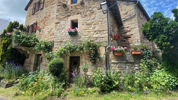 A stone building with flower boxes and a street lamp. - New gîte in vimenet (Aveyron) medieval village between aubrac and lévézou  (Vimenet)