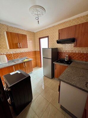 A kitchen with wooden cabinets, a refrigerator, a stove, and a built-in oven.