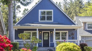 A two-story house with a dark blue exterior, white trim, and a front porch with a black door. - Spacious 3-BR Bella Beach, Hot Tub,  Master w/King (Depoe Bay)