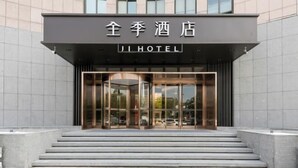 The entrance to Ji Hotel with a modern facade, glass doors, and a set of steps leading up to the entrance. - JI Hotel (Jiaxing Zhongshan Road) (Jiaxing)