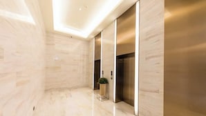 A modern elevator area with marble flooring and a glass partition. - JI Hotel (Jiaxing Zhongshan Road) (Jiaxing)