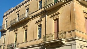 A multi-story building with balconies, large windows, and decorative moldings. - HABITARE Lecce & Salento (Lecce)