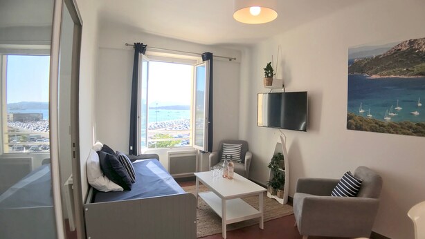Una sala de estar moderna con una cama, una mesita de centro y un televisor.