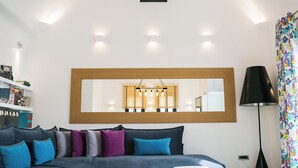 Ein modernes Schlafzimmer mit einem großen Bett, einem Nachttisch, einem Spiegel und einer Lampe.