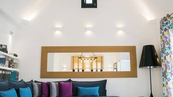 Un dormitorio moderno con una cama grande, una mesita de noche, un espejo y una lámpara.